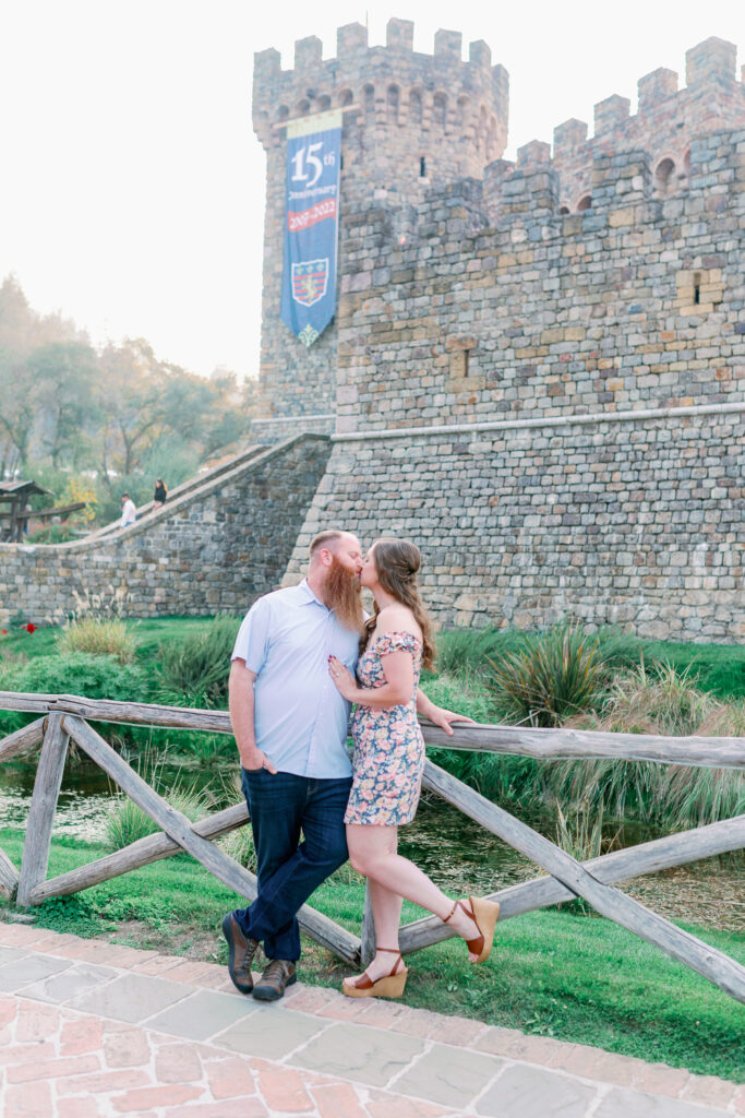 couple kissing during their engagement session at Castello Di Amorosa in Napa Valley California engagement photos by Sarah Schweyer Photography