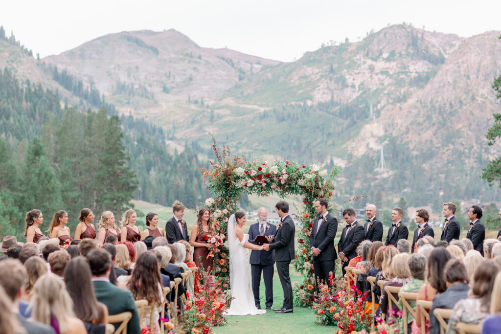 bride and groom getting married in front of their friends and family and bridal party with epic mountain views in the background in Tahoe California