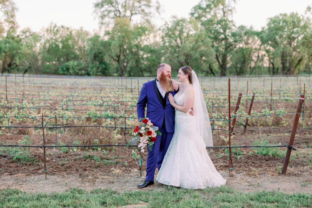 bride and groom smiling at each other in a vineyard in sacramento california